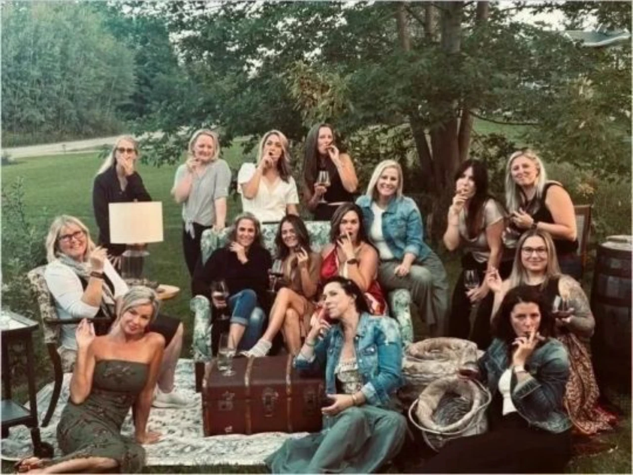 Women smoking cigars at backyard gathering