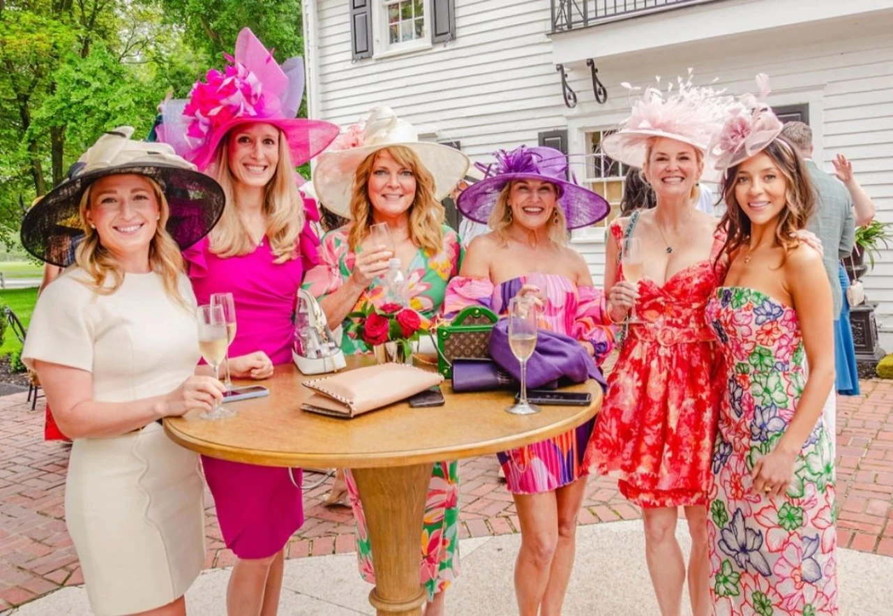 Women wearing colorful dresses and large hats