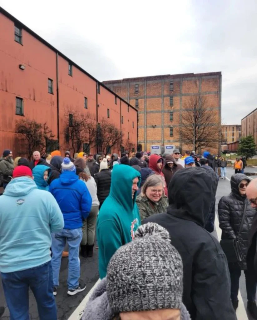 People in winter clothing outside brick warehouses