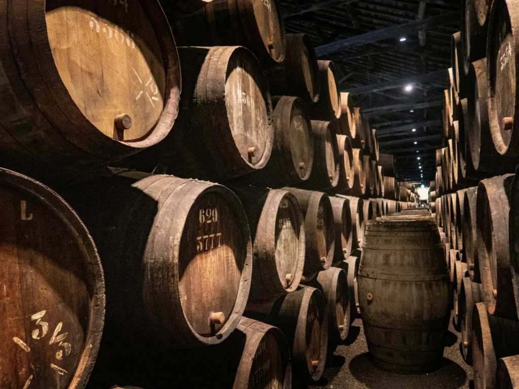 Rows of stacked wooden barrels in cellar