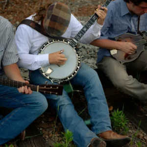 Three musicians playing banjo and mandolin outdoors