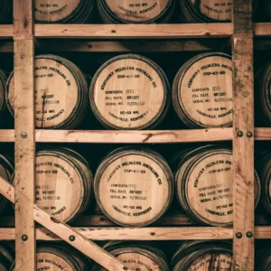 Whiskey barrels stacked on wooden racks in distillery